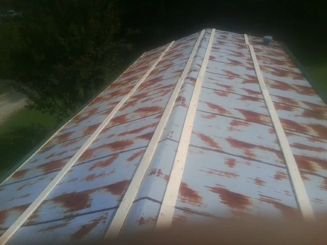 Rusted metal roof panels with new wood purlins before replacement — Storm Damage Roof Repair in Dana by Roofing Brothers
