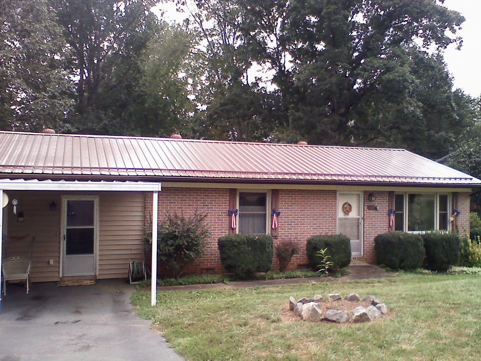 Bronze metal roof and carport on a brick ranch home — Roof Repair work by our crew in Dana